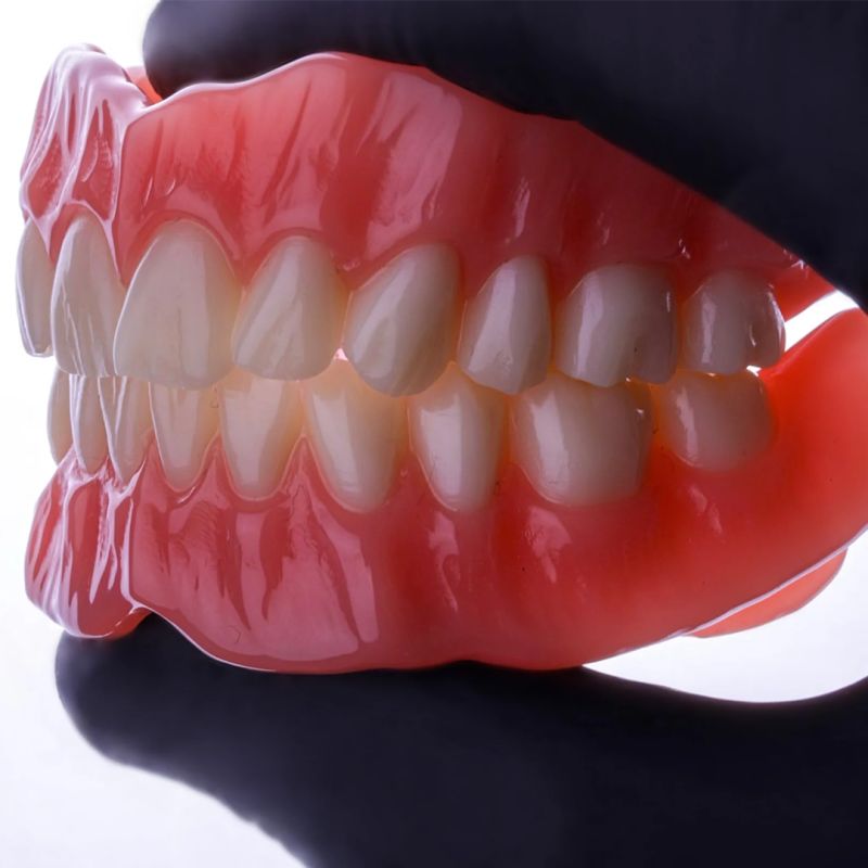 Prothèse dentaire complète amovible avec gencives roses et dents blanches fabriquée au laboratoire numérique Digidental
